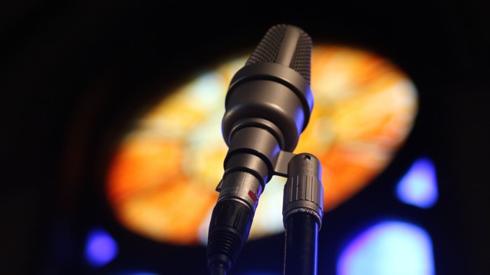 Ein Mikrofon vor einem farbigen Hintergrund.