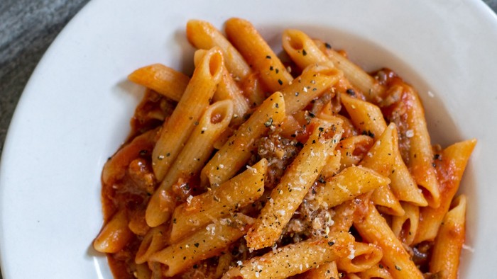 En bolle med penne med tomat sauce og ost