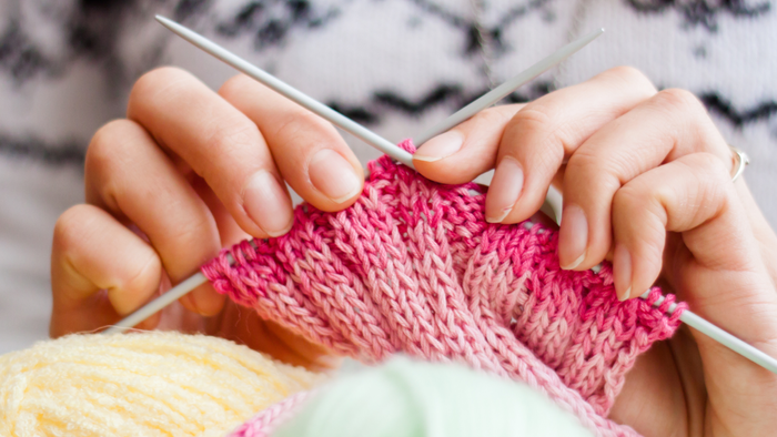 En person spinder en rosa og gule trøje.