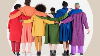 Eine vielfältige Gruppe von Menschen, die eng beieinander in bunten, mehrlagigen Mänteln stehen und Einheit und Unterstützung zeigen.