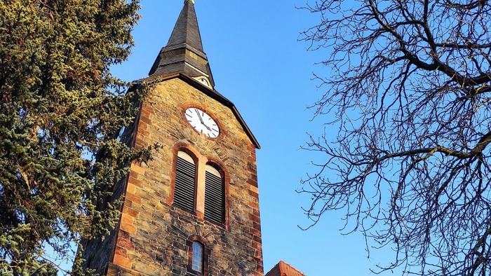 Gotische Kirche mit hohem Turm und Uhr.