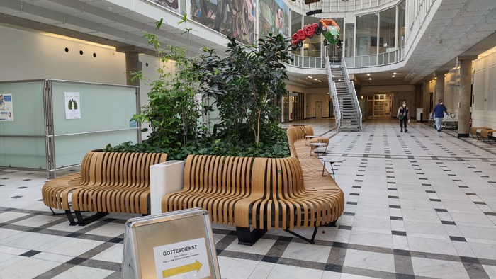 Modernes Einkaufszentrum mit Sitzbänken und Grünpflanzen