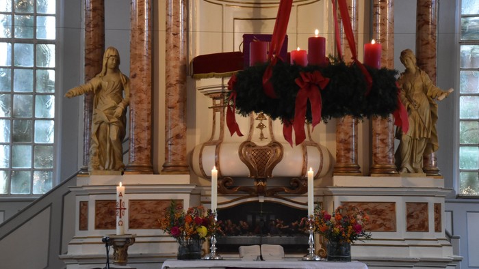 Gepflegte Kirchenaltäre mit Kerzen und Blumendekoration