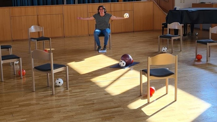 Ein Mann steht in einem großen Raum mit Holzboden und spielt Videospiele.