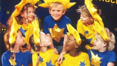 Kinder in sonnenthematischen Kostümen posieren gemeinsam.