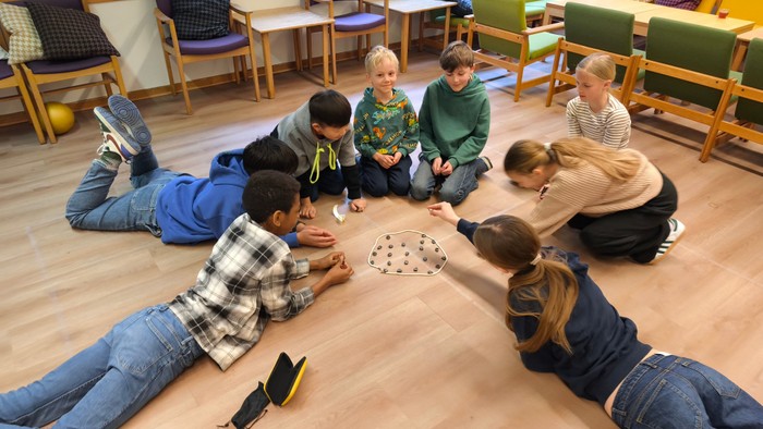 Børn spiller på gulv i legetøjsrum