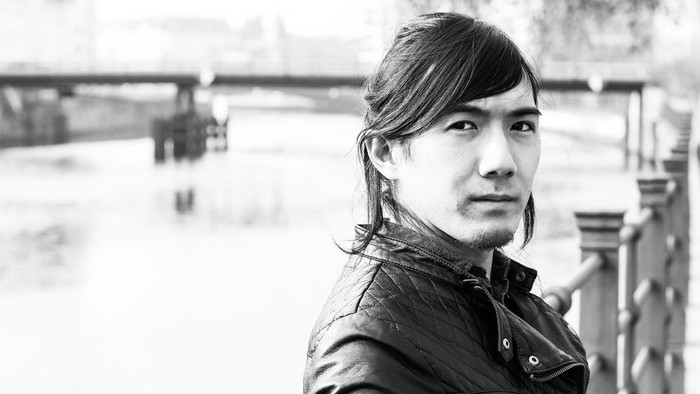 Hisato Tsuji, im Hintergrund eine Brücke in Berlin