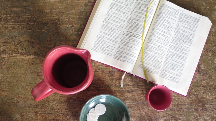 Geöffnetes Buch mit Kaffeetassen auf einem Holztisch