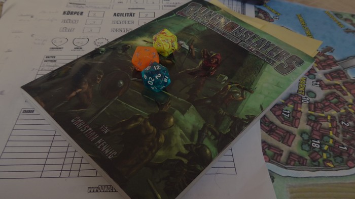 Ein Tischrollenspiel-Setup mit Würfeln und Karten.