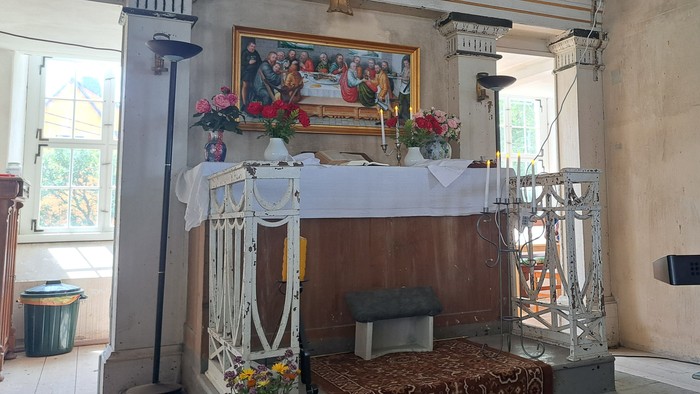 Ein Mann spielt Keyboard in einem Raum mit Altar und Bildern