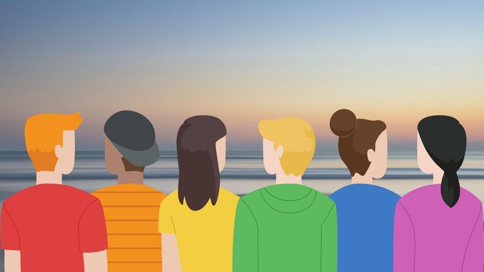 Eine Gruppe von Menschen schaut bei Sonnenuntergang aufs Meer