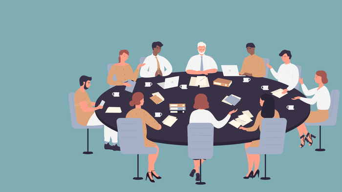 En gruppe af professionelle sidder om et bord og diskuterer dokumenter.