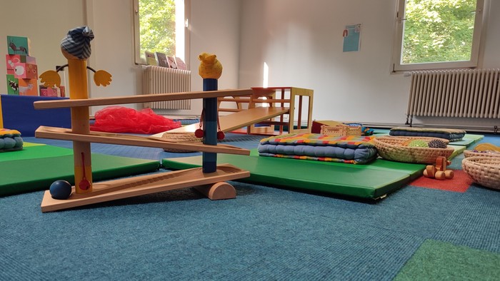 Ein Kinderzimmer mit Spielzeug und Matten auf dem Boden