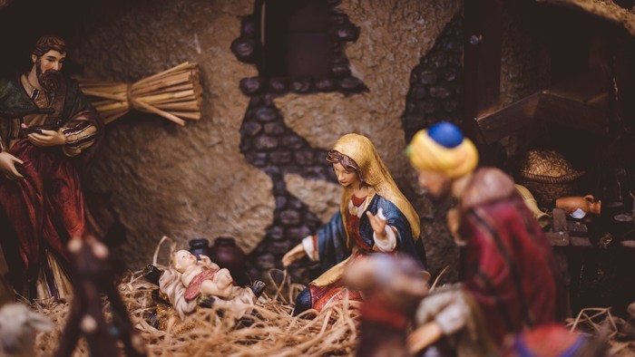 Nativity scene with figures and straw.