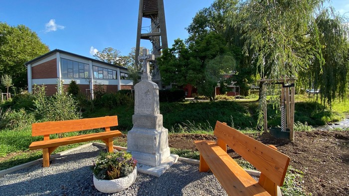 Im Park: Denkmal mit Bänken und Haus im Hintergrund