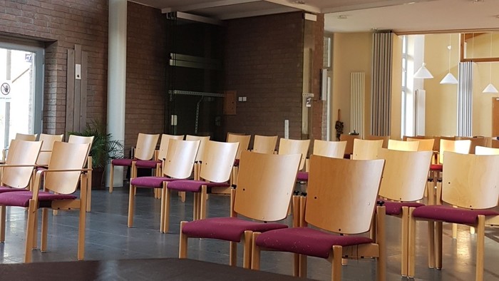 Modernes Café mit hohen Decken und Holzstühlen