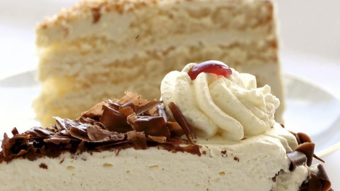 Zwei Stücke Kuchen mit Schlagsahne und Schokoraspeln.