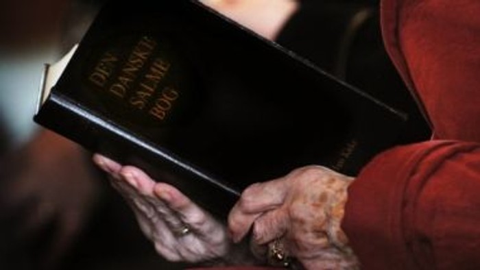 En person holder en håndskrevet bibel.