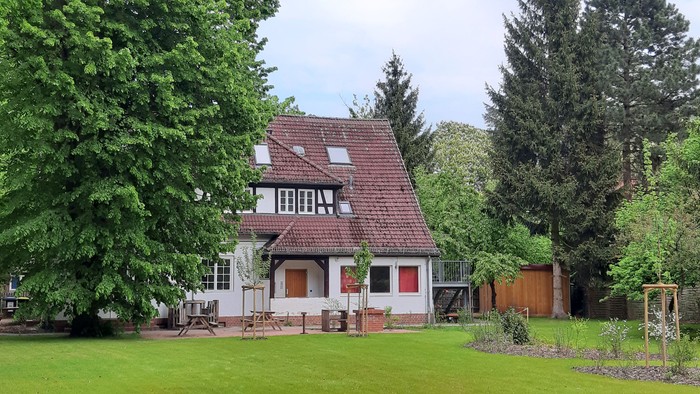 Hübsches Haus mit Garten und Bäumen.