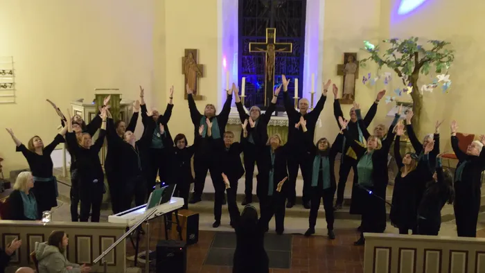 Eine Gruppe von Menschen singt in einer Kirche
