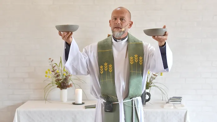 Indstiftelse af nadver med brød. To skåle med brød, som Ole Backer Mogensen holder