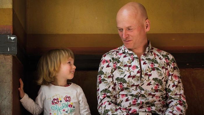 Ein Mann und ein junges Mädchen sitzen zusammen auf einer Bank.