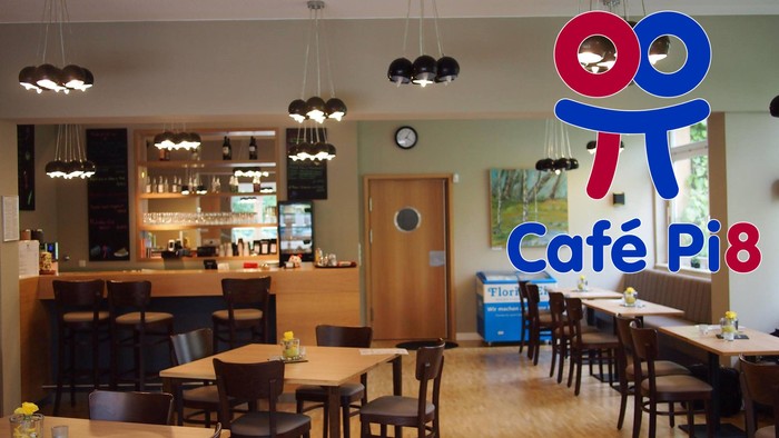 Gemütliches Café mit Holztischen und -stühlen, moderne Beleuchtung, und ein einladendes Ambiente