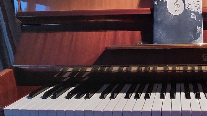 Ein Piano mit Notenbüchern und einem Notizbuch darauf