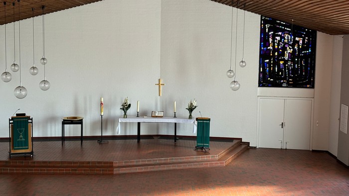 Moderne Kirche mit Holzaltar, farbigen Fenstern und modernen Lichtern