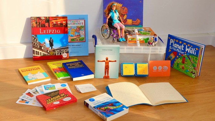 Verschiedene Kinderbücher und Bastelmaterialien auf einem Holztisch