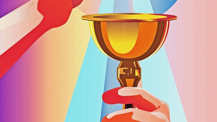 Zwei Hände halten einen goldenen Kelch mit Hostie und Lichtstrahlen