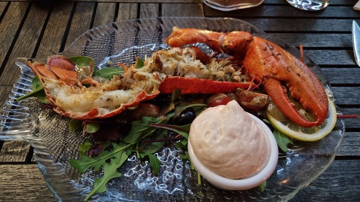 Teller mit Hummer in Sauce und Zitronenspalte