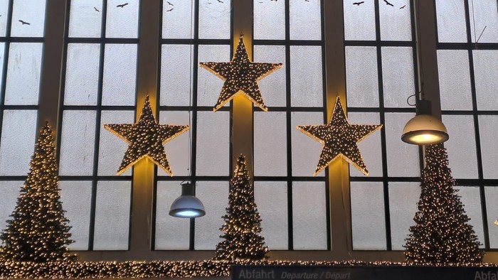 Der Innenbereich des Hauptbahnhofs, Fenster geschmückt mit leuchtenden Sternen und Bäumen