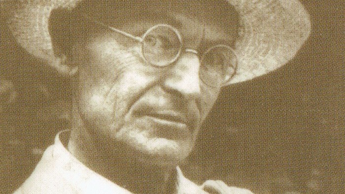 Alter Mann mit Strohhut und Brille.