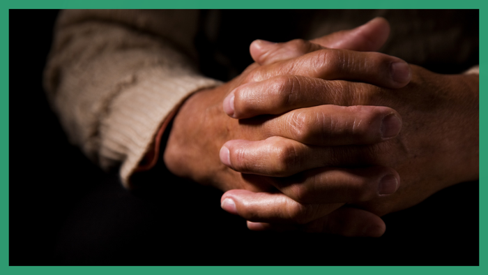 Two hands clasped together, fingers intertwined.