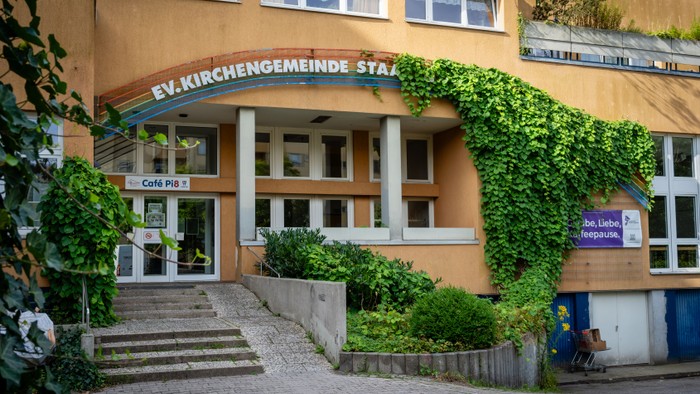 Gebäude mit Schild „FV.KIRCHENGemeinde STADT“ und Treppe zum Eingang.