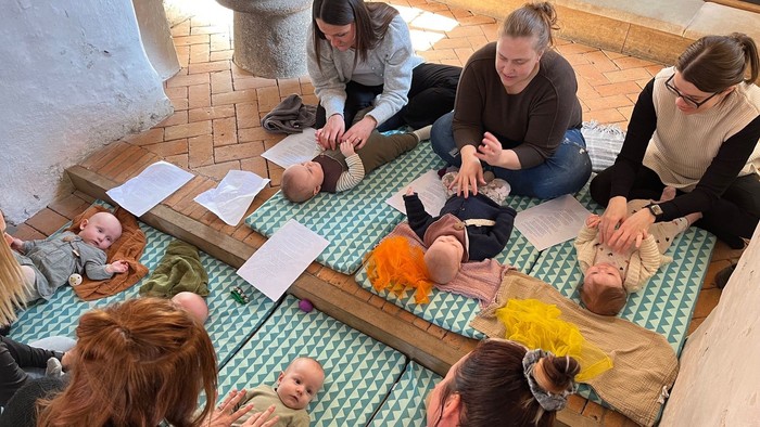 Forældre med deres babyer nyder musik på kirkegulvet