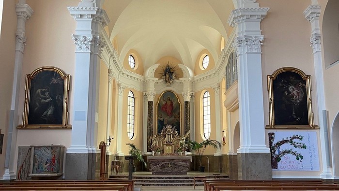 Innenraum einer Kirche mit Holzstühlen und Altären
