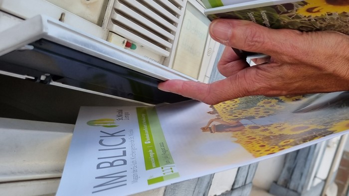 Person steckt Brief in den Briefkasten Nr. 16