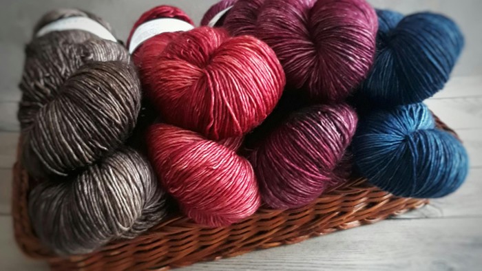 En korb med forskellige farvede garnspinder.