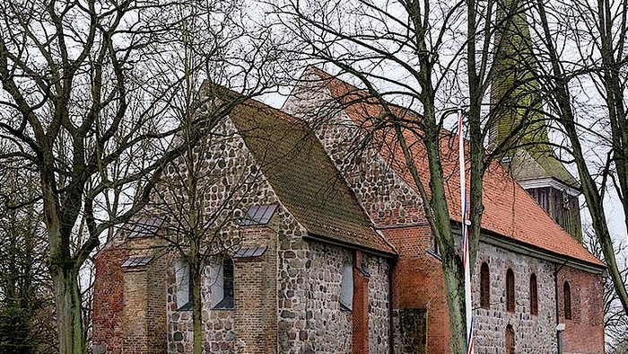 Alte Kirche aus Backstein und Holz in parkähnlichem Gebiet