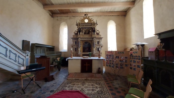 Innenraum einer Kirche mit Altar und Buntglasfenstern