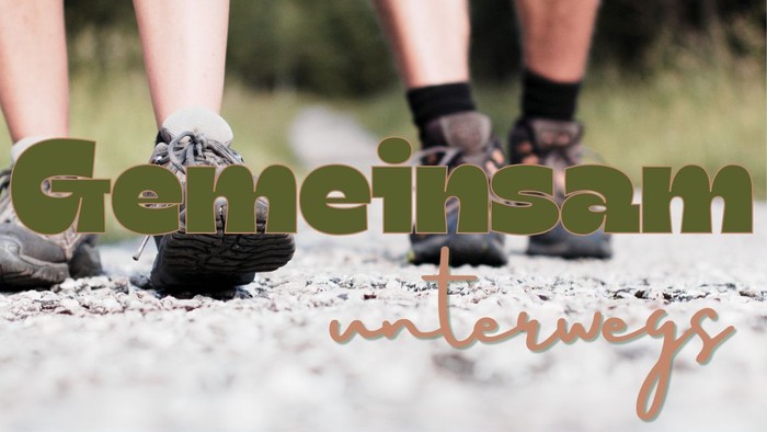 Zwei Personen in Wanderschuhen auf einem Schotterweg