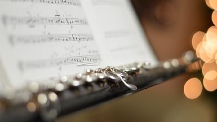 Ein Musiker spielt Flöte nach Noten.