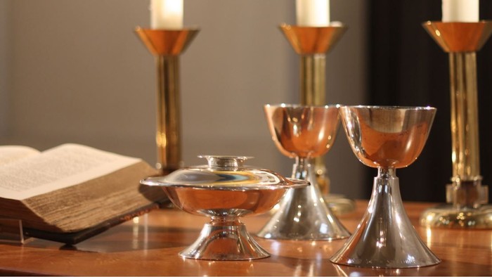 Ein Tisch mit Kerzen, einem Buch und Gläsern