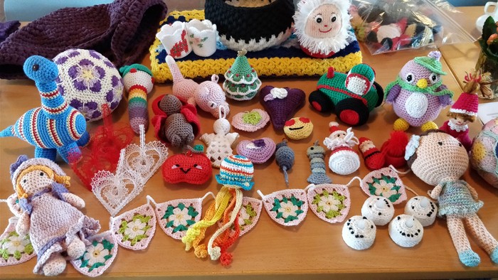 Billedet viser en samling af håndarbejdede doppelgængere og dekorationer, herunder dyr, figurer og smykker.