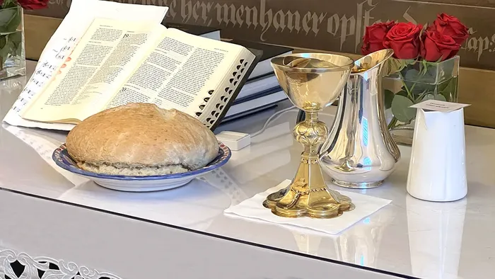 Alter med røde roser, bibel, vin og brød