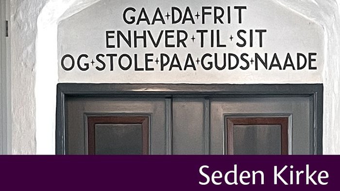 Dobbelt dør med indskrift i oldnordisk på hvide murværk