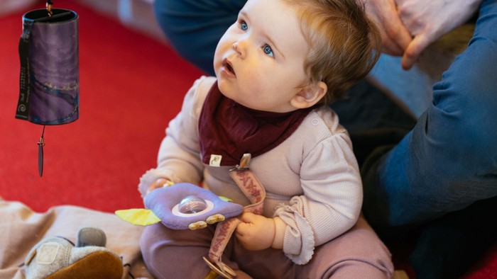 Et barn spiller med legetøj på en rød underlag