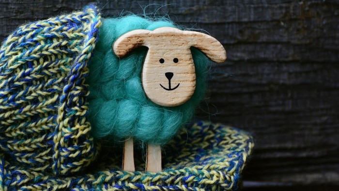 En håndklædt skurdespindel med træhoved og ben.